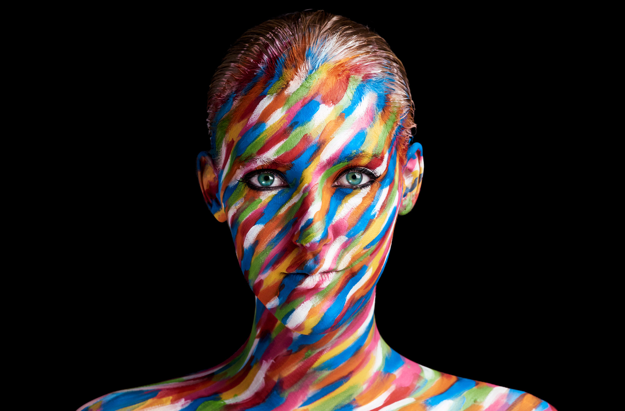 Female face painted in smudges of different color