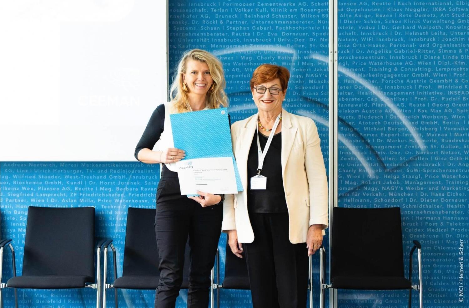 Dean of USWPS's Faculty of Social Sciences shows certificate of CEEMAN membership