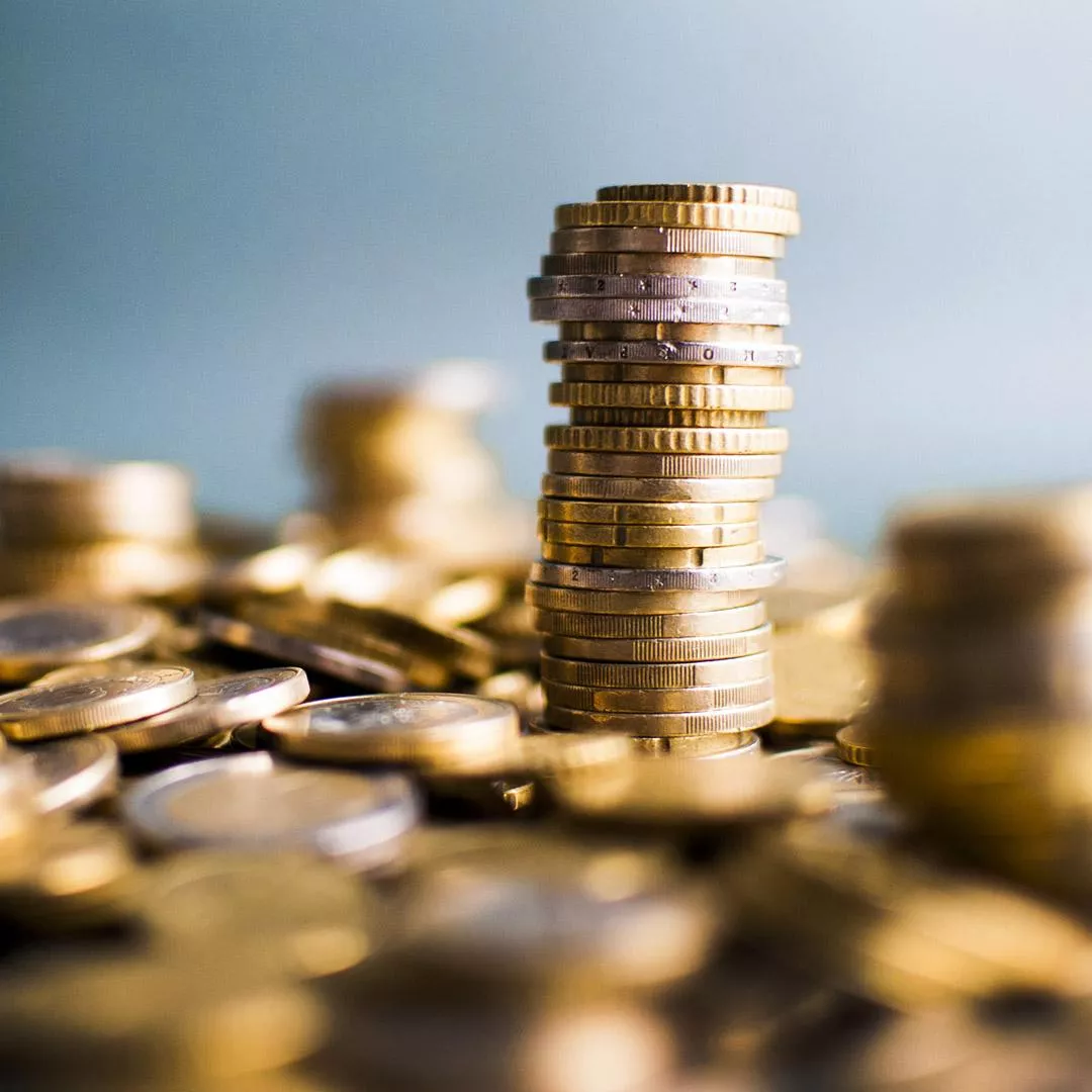 Stack of gold coins among a sea of gold coins