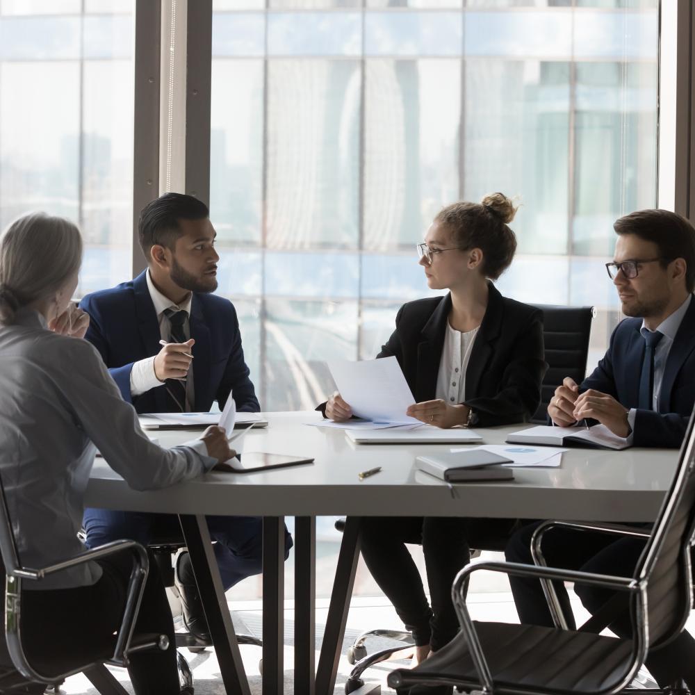 Group of young professional sit around a table discussing a legal case