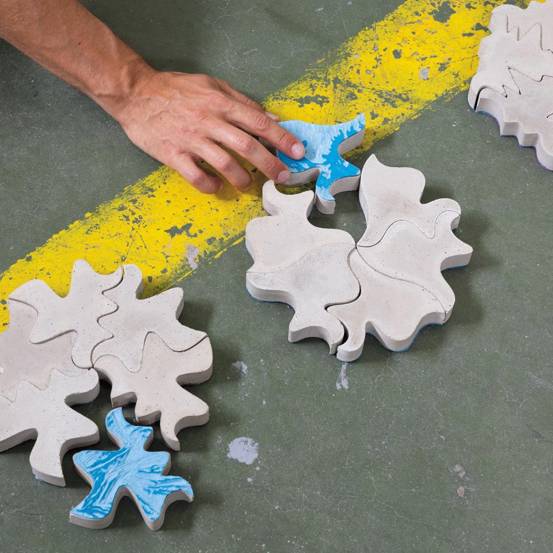 Organically-shaped ceramic tyles being laid on the floor
