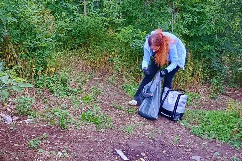 Female student from USWPS gathers trash on the banks of the Vistula river