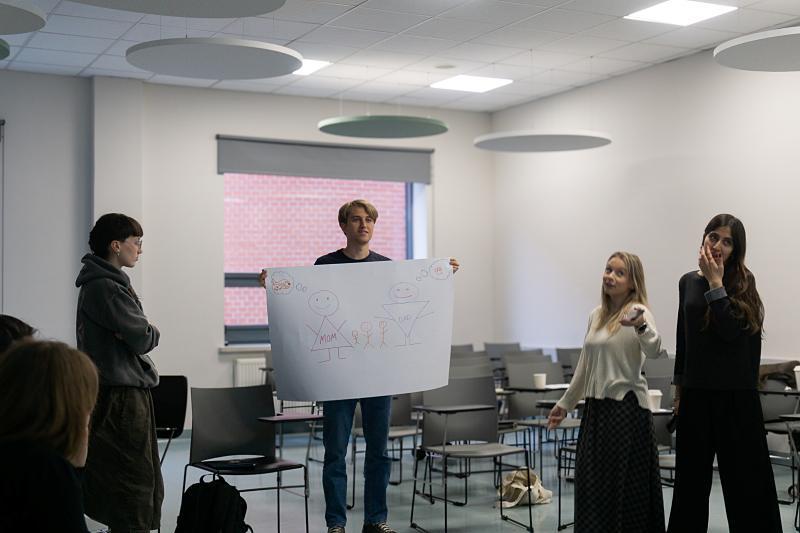 Four student present their concept on a poster during a workshop