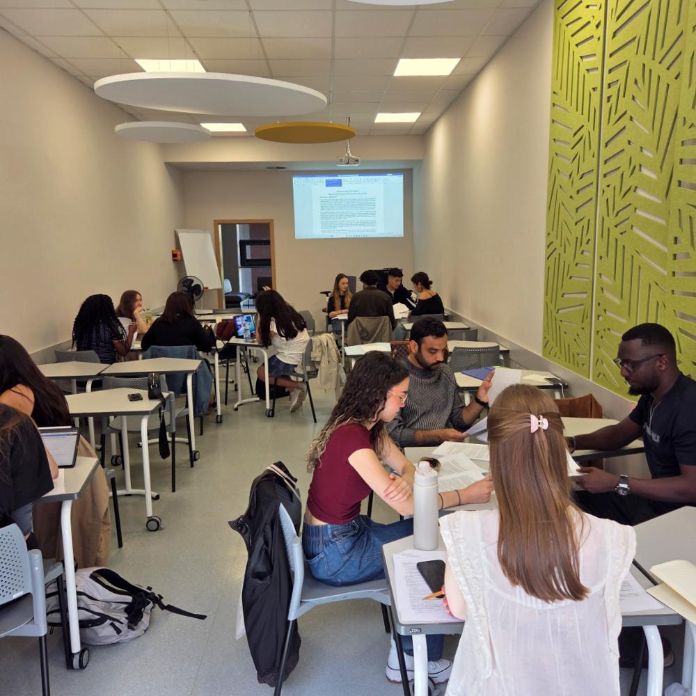 Groups of international students work on projects in a classroom