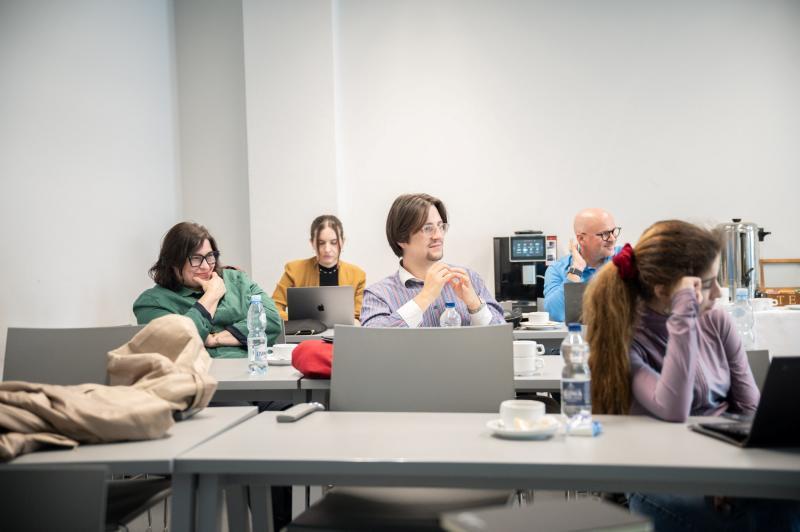 Group of doctoral students listen to a lecture in a classroom