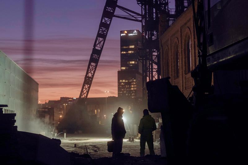 Two men standing in the industrial area of the Nikiszowiec district of Katowice Poland at dusk