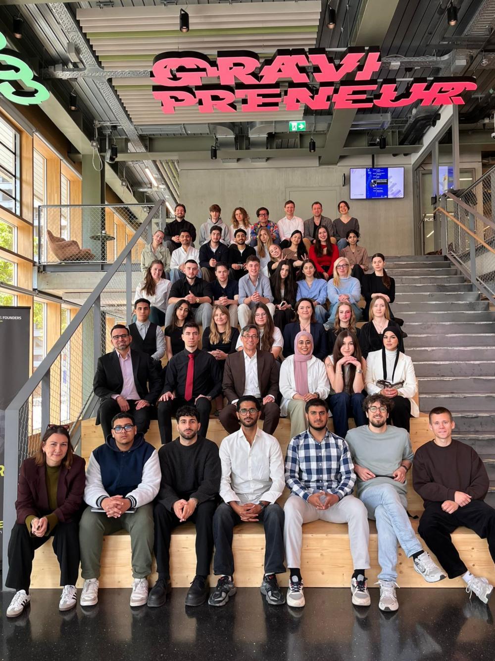 International students sit on the stairs at Campus Founder in Hailbronn Germany