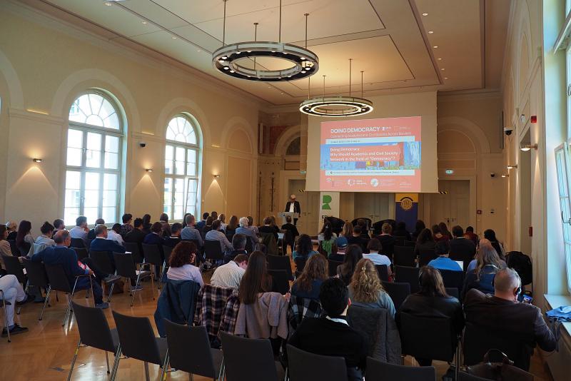 Large group of students and academics listening to a lecture in a grand lecture hall