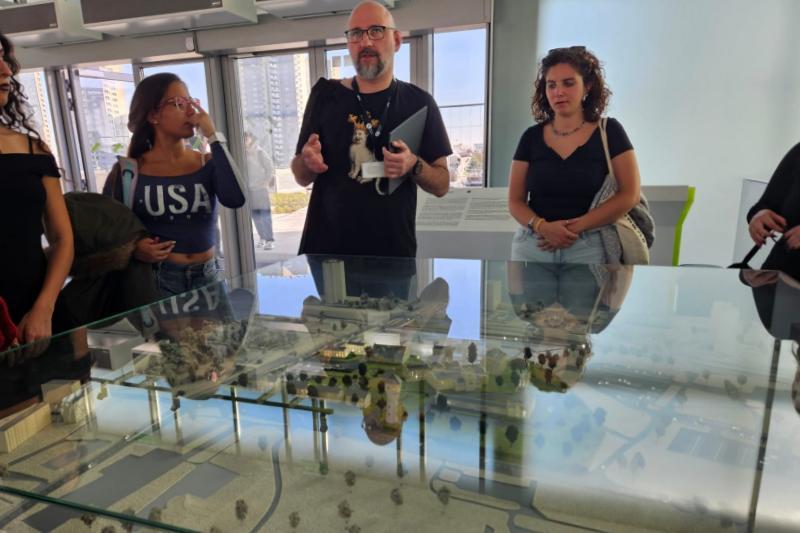 Museum guide showing students a model display of a town at the Silesian Museum
