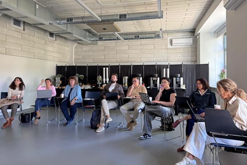 Participants of the AI-CARE project sit in a circle during workshop at USWPS