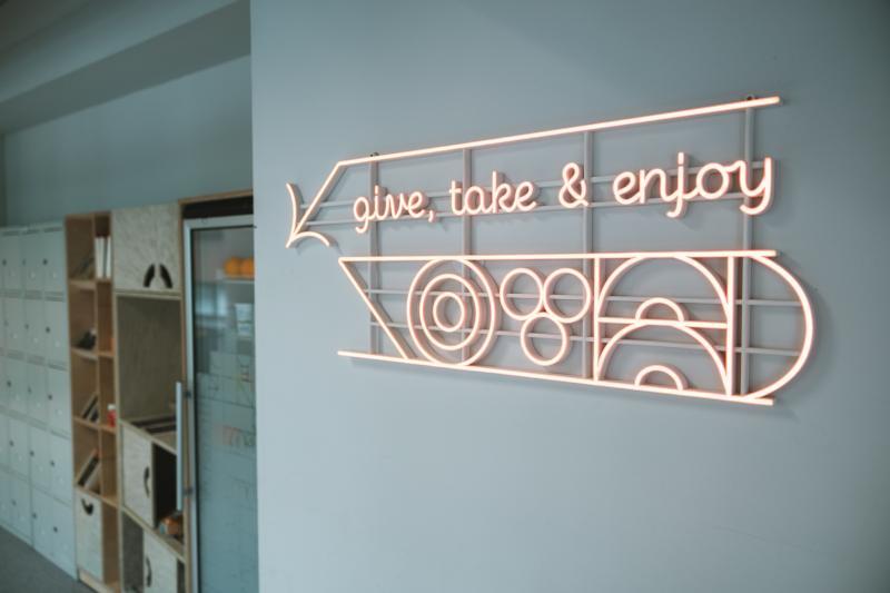 Neon with slogan Give, take & enjoy at USWPS Food Sharing Corner