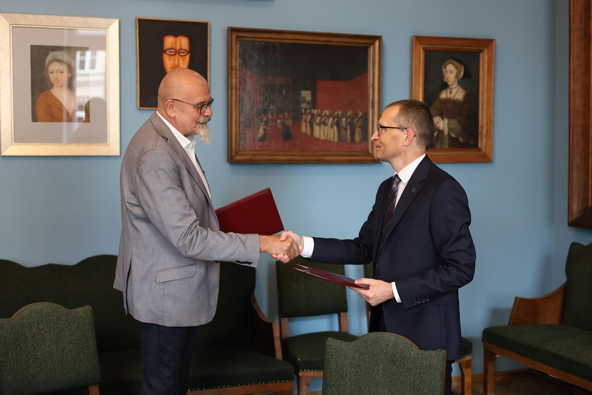 A handshake between the Rector of SWPS University and the Rector of the Academy of Fine Arts in Krakow.