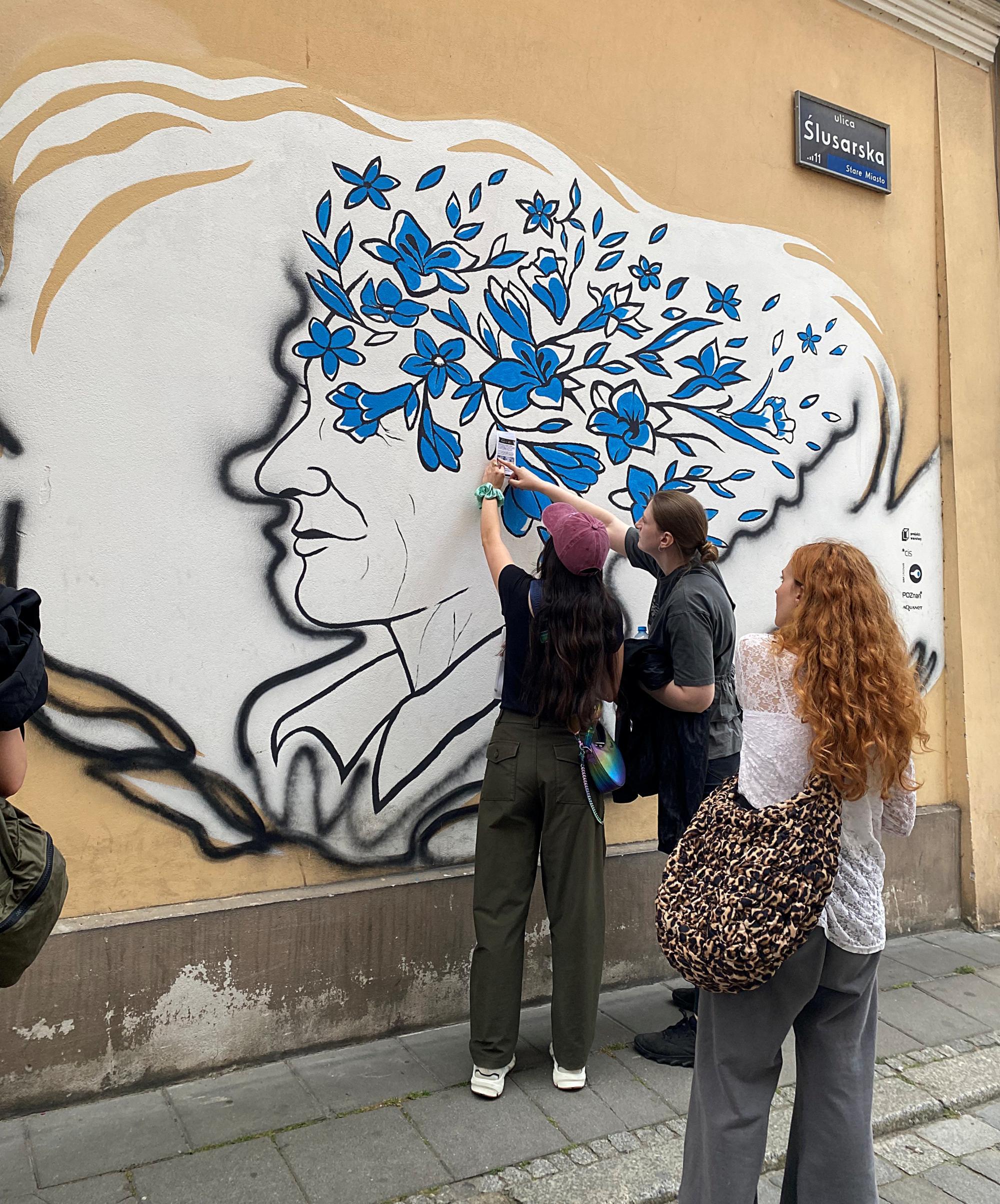 Students admiring mural symbolizing mental health in Poznan, Poland