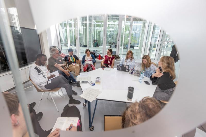 Students sitting around a table during conference workshop