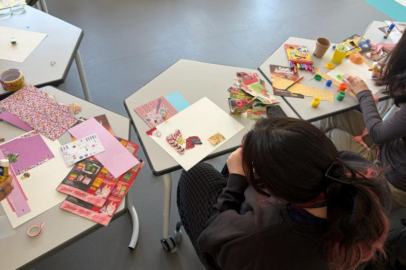 Students sitting at desks work on their artworks