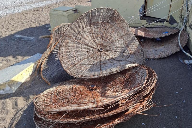 Traditional Greek kalathos baskets piled up on a beach in Rhodes, Greece