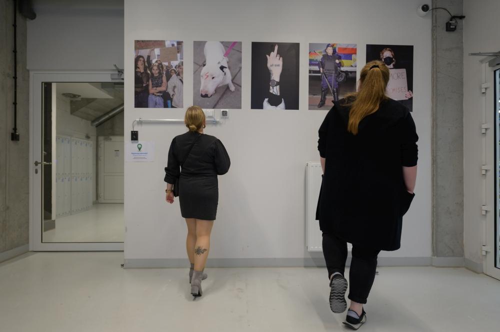 Two women watching the poster exhibition at SWPS University in Warsaw