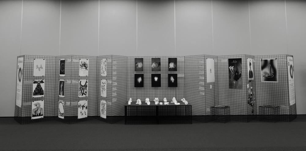 A horizontal view of the DesignAIR exhibition, showcasing an array of prints and ceramics; the photo is black and white