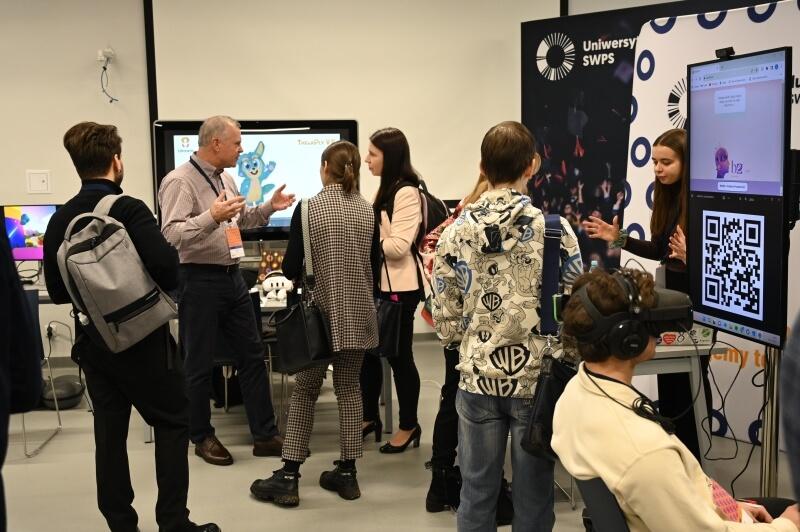 Attendees exploring the exhibition space at HumanTech Summit 2023, engaging with various technology displays and startup booths