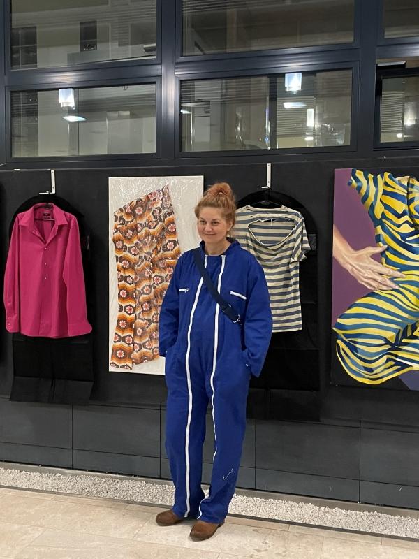 A woman standing in front of artworks at the “Inbetween” exhibition at SWPS University in Kraków