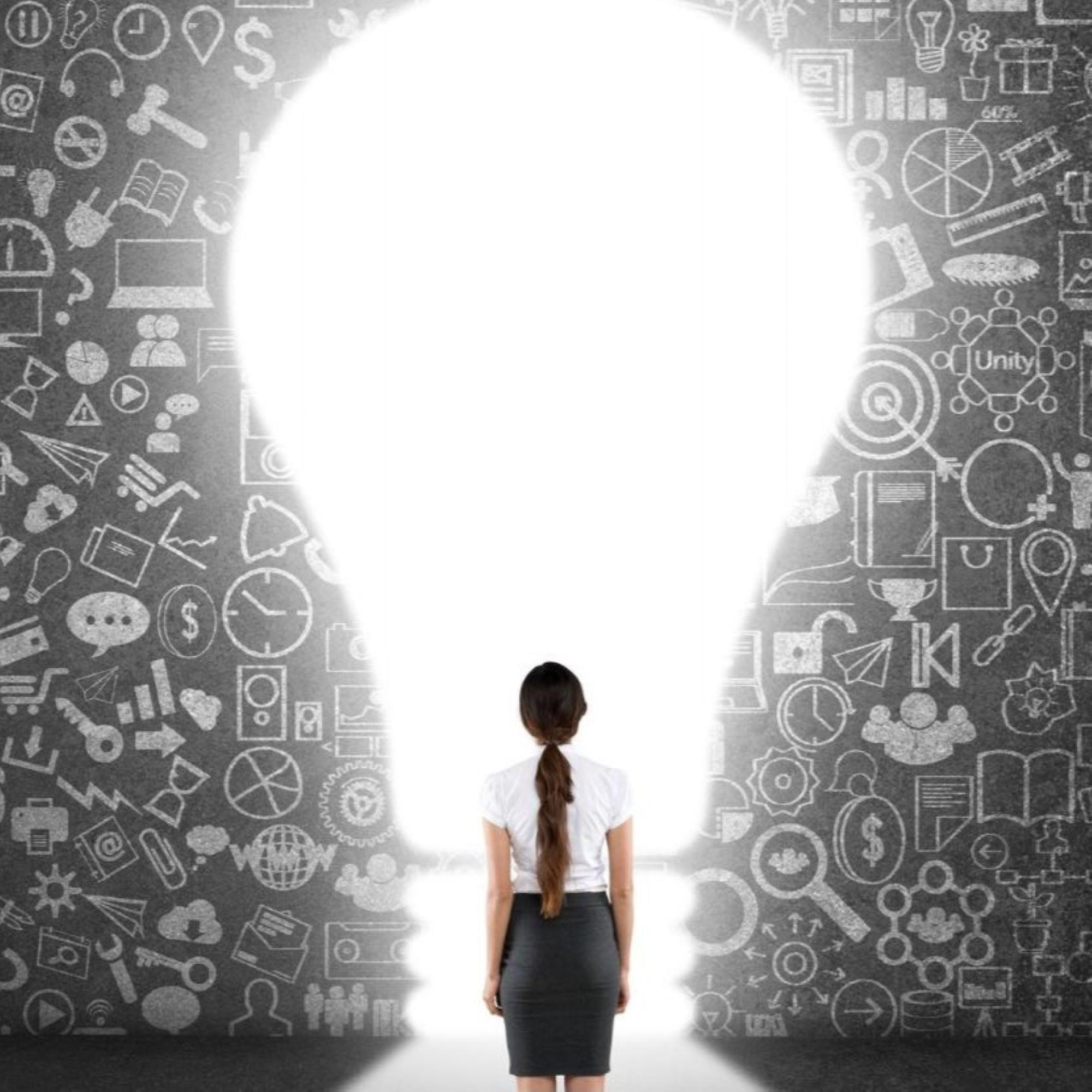 A girl standing in front of a large light bulb