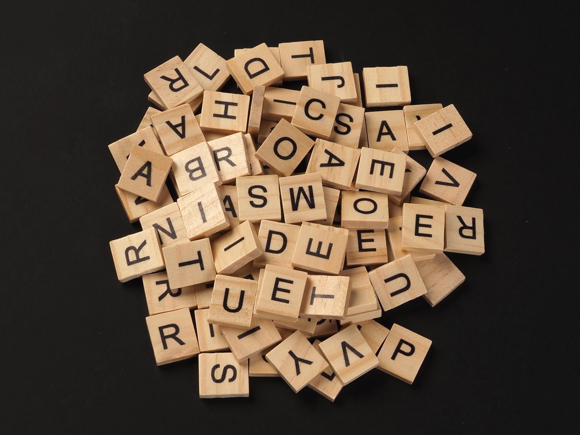 A pile of wooden building blocks with printed letters