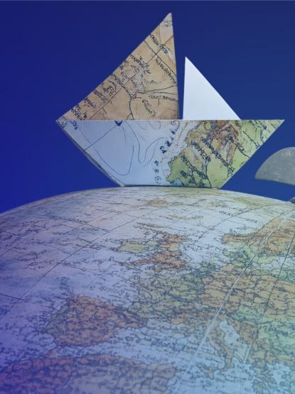 Small boat made of maps sailing the circumference of a big globe