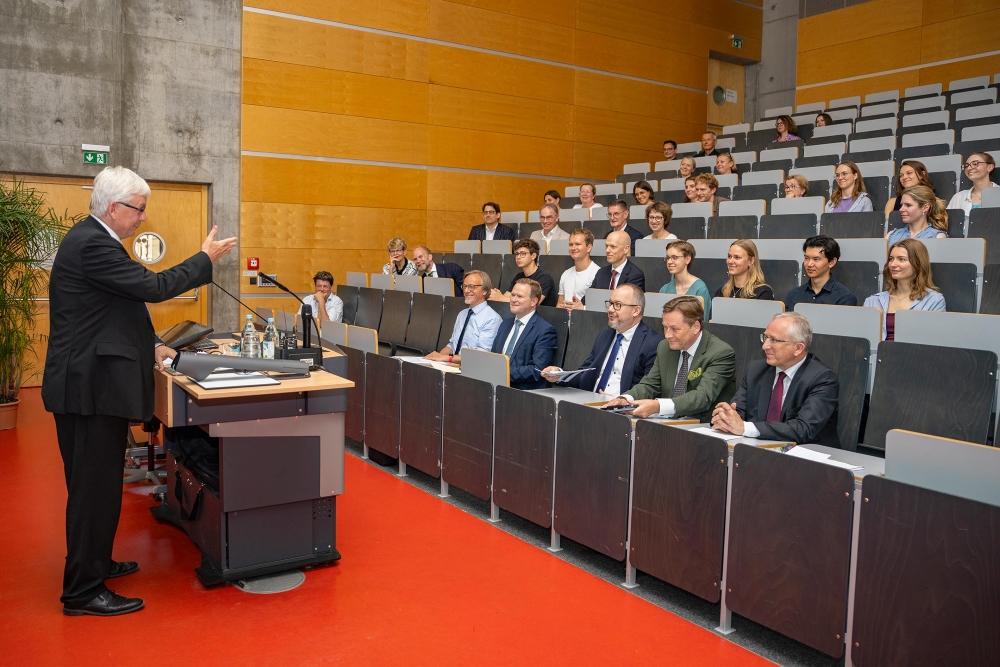 Professor Andreas Zimmermann delivers the laudatory speech and points to Adam Bodnar who sits among the audience