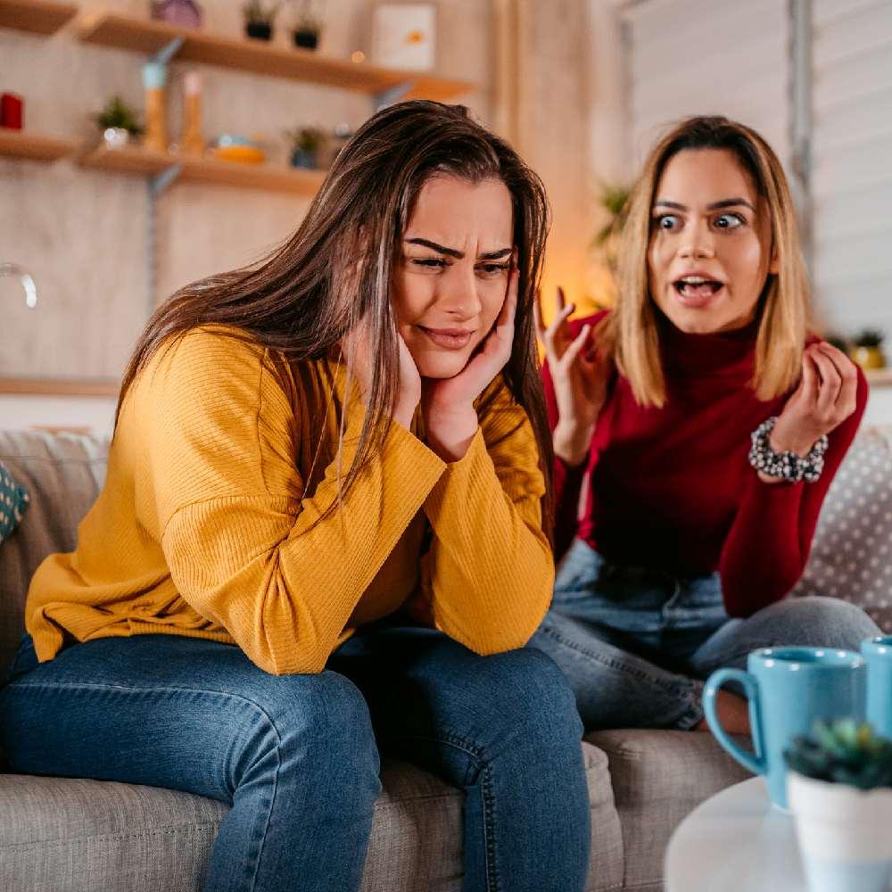 woman shouting at another woman on sofa