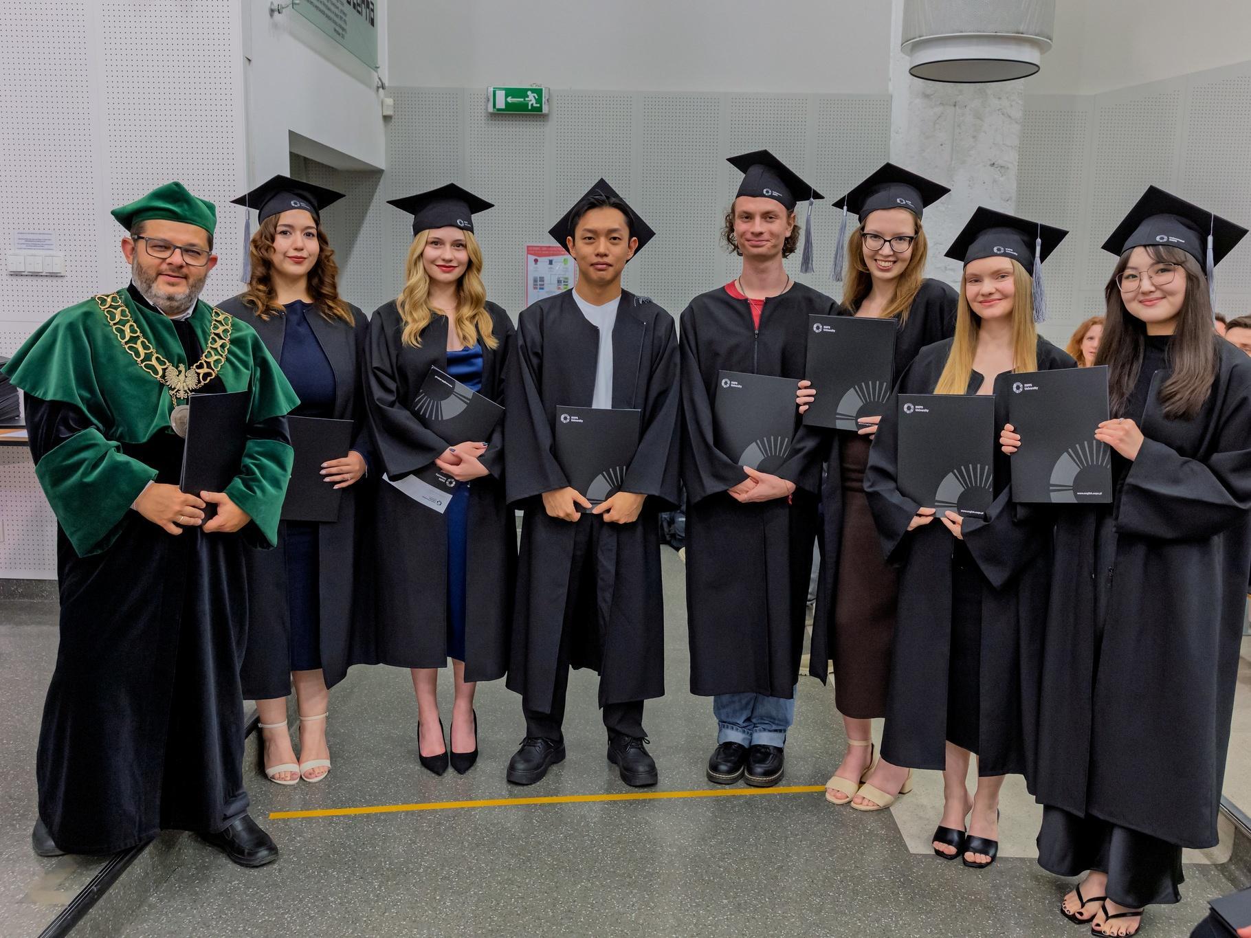 Graduates posing with the Dean of the Faculty of Psychology in Wrocław